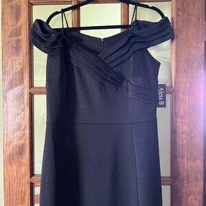 Black floor length gown with slit , new with tags.